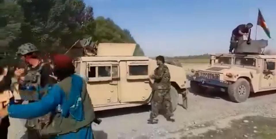 Taliban insurgents secure Humvee trucks surrendered by Afghan troops