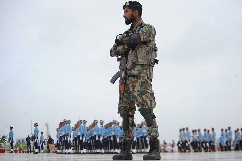 A Pakistani soldier stands guard as Pakistan Air Force soldiers attend a ceremony in Karachi. EPA