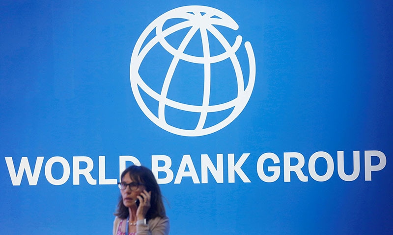 A participant stands near a logo of World Bank at the International Monetary Fund - World Bank Annual Meeting. — Reuters/File