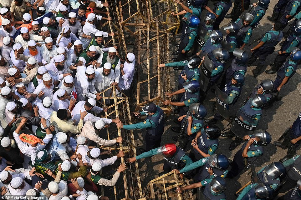 Protesters try to tear down barbed wire barricades that police had set up to keep them away from the French embassy during protests in Dhaka on Tuesday