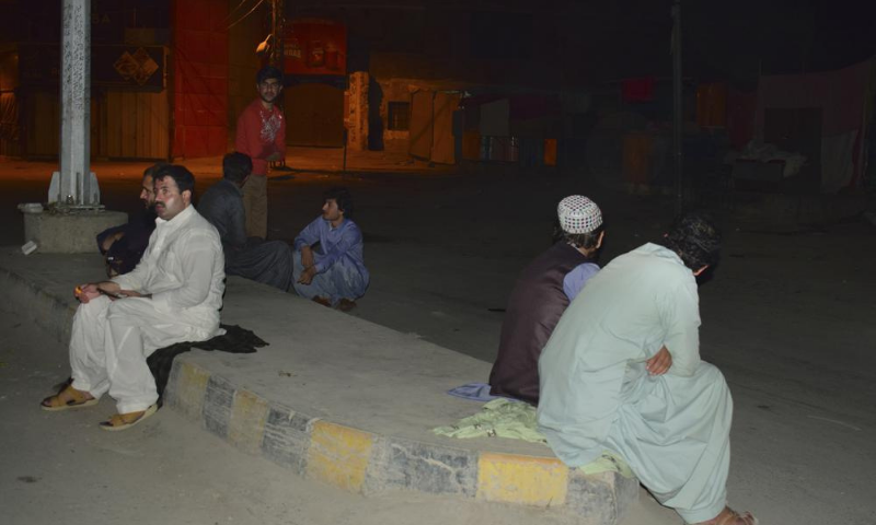 People gather outside their houses following a severe earthquake, in Quetta on Thursday. — AP