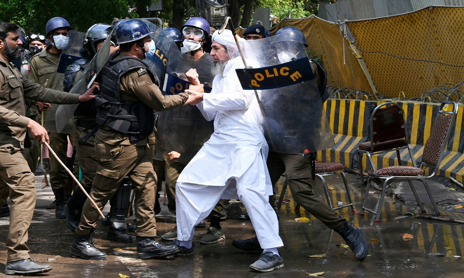Riot police detain a supporter of former prime minister Imran Khan at Zaman Park in Lahore on March 18, 2023, whilst Khan was leaving for Islamabad to appear in a court. —Photo by Arif Ali/AFP
