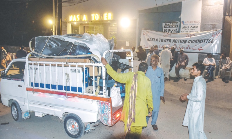 LAST of the occupants take away their belongings to vacate Nasla Tower on Thursday evening.— Fahim Siddiqi / White Star