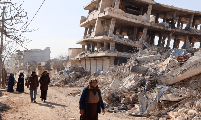 <p>Residents walk along destroyed buildings, as search and rescue operations continue days after a deadly earthquake hit Turkey and Syria, in the town of Jindayris, in the rebel-held part of Syria’s Aleppo province, on February 10. — AFP</p>