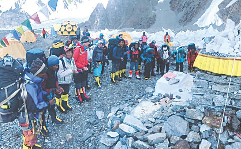 NEPALESE climbers hold puja at base camp before setting off.—Dawn