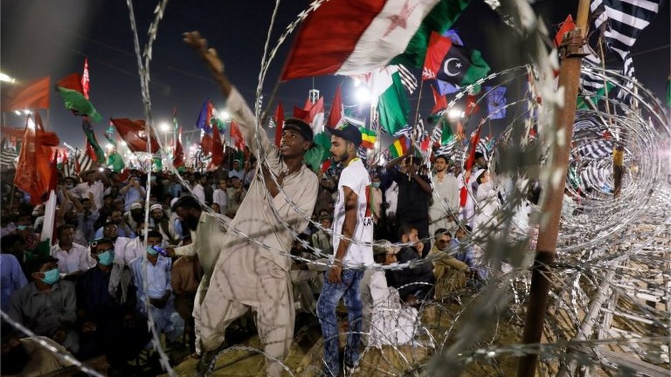 A supporter of the Pakistan Democratic Movement (PDM), an alliance of political opposition parties, reacts to a party song during an anti-government protest rally in Karachi, Pakistan October 18, 2020.