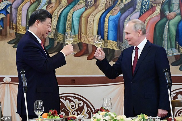 In his new book, expert Charles Dunst warns that democracy is now in a fight with autocracy for control of the future. Pictured: China's president Xi Jinping (left) and his Russian counterpart Vladimir Putin (right) share a toast during their meeting in Moscow on Tuesday