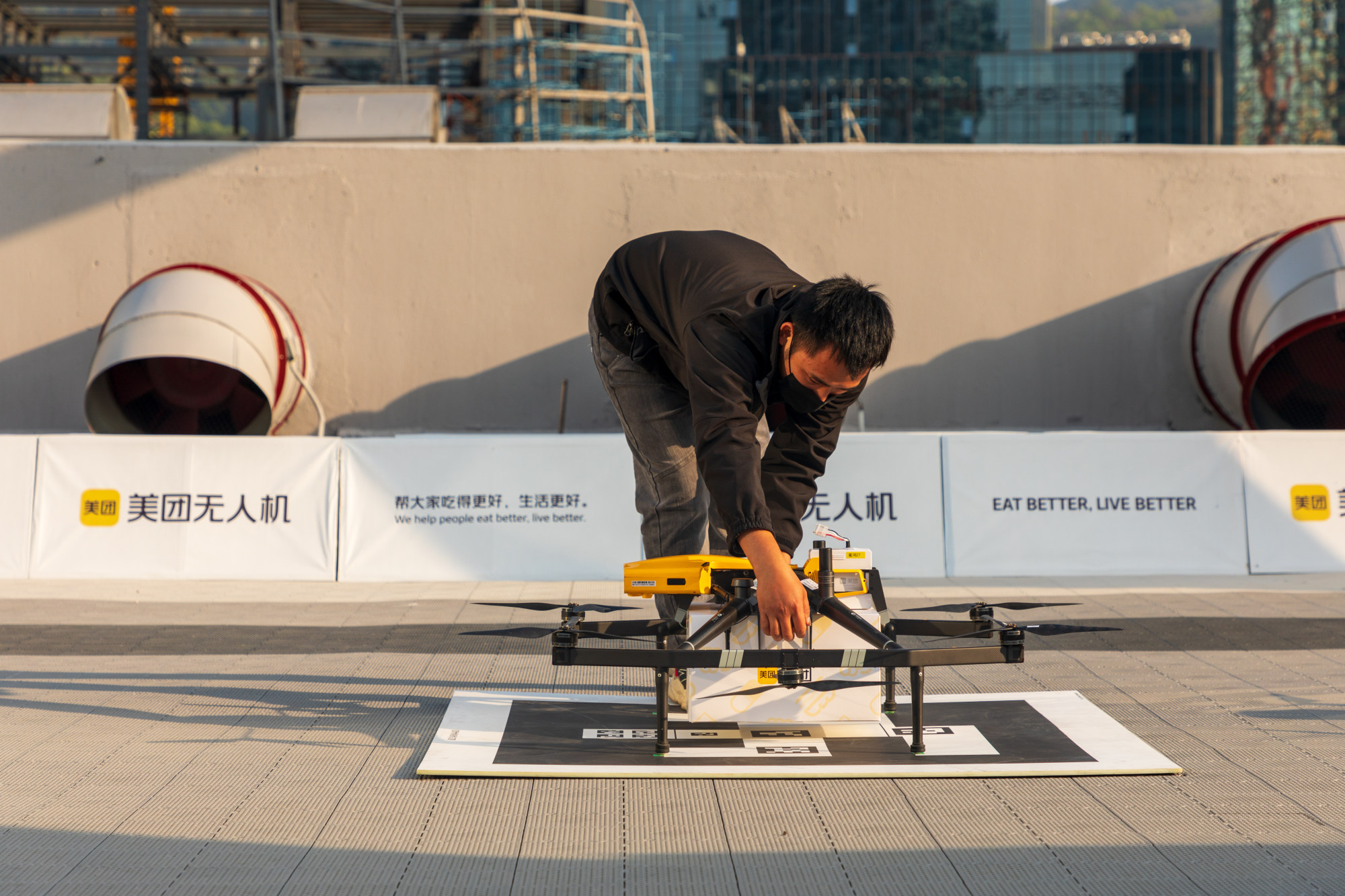 A Meituan employee fixes a delivery box to a drone. Photo: Getty Images