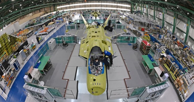 Workers of Korea Aerospace Industries (KAI) assemble the first prototype of the nation's indigenous fighter jet program KF-X at a plant in Sacheon, South Gyeongsang Province, Jan. 22. / Korea Times file