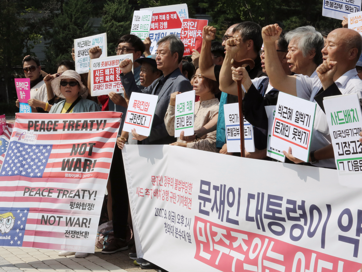 protesters-on-monday-held-signs-saying-we-denounced-the-deployment-of-an-advanced-us-missile-defense-system-thaad.jpg
