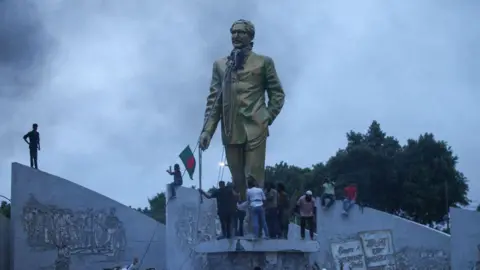 Getty Images Demonstrators attempting to tear down a statue of Ms Hasina's father, Sheikh Mujibur Rahman