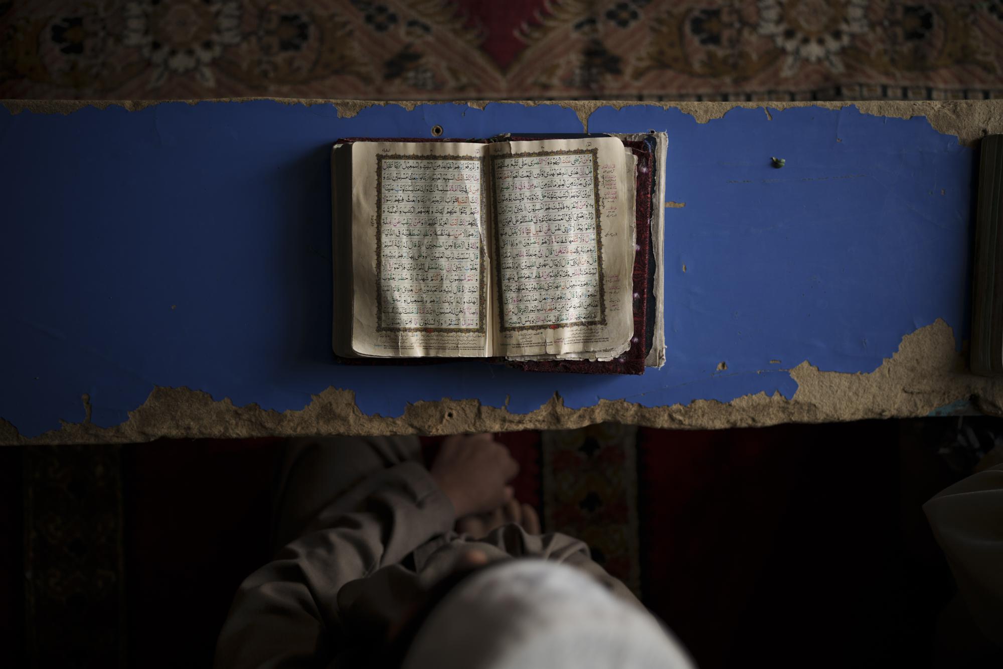 FILE - A student reads the Quran at a madrassa in Kabul, Afghanistan, Tuesday, Sept. 28, 2021. The American concept of adoption doesn’t exist in Afghanistan. Under Islamic law, a child’s bloodline cannot be severed and their heritage is sacred. Instead of adoption, a guardianship system called kafala allows Muslims to take in orphans and raise them as family, without relinquishing the child’s name or bloodline. (AP Photo/Felipe Dana, File)