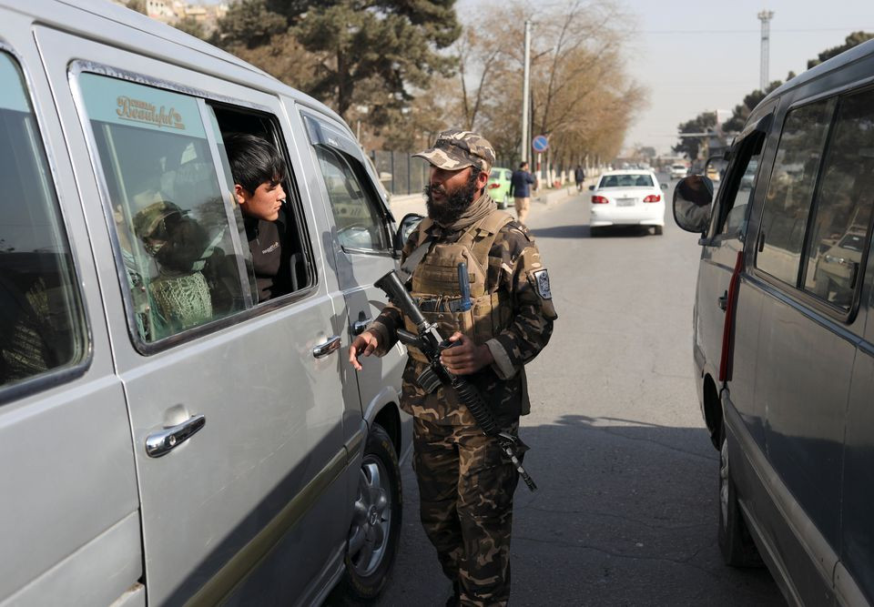 a taliban fighter searches a car as he guards a checkpoint in kabul afghanistan november 27 2021 photo reuters