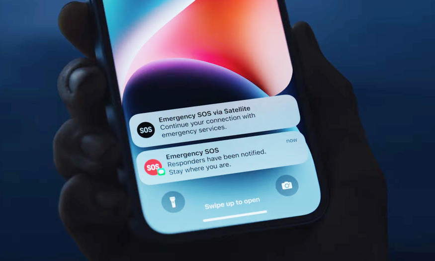 A hand holds up an iphone in a dark show and shows the Apple's Emergency SOS feature on the screen. Responders have been notified. Stay where you are.