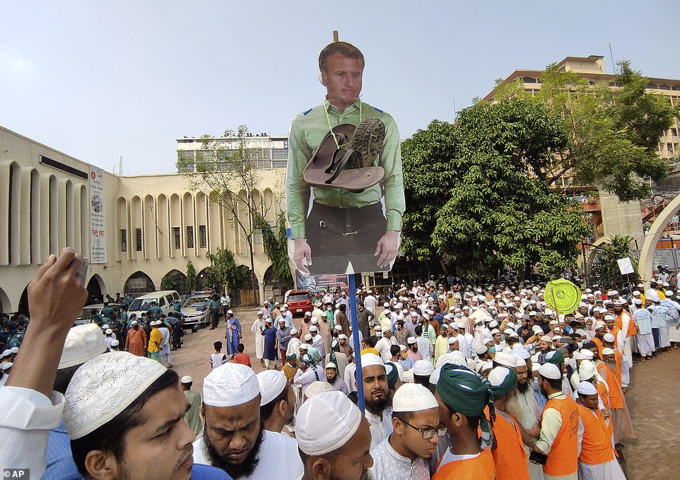 An effigy of Macron with shoes tied around his neck - intended as a disrespectful gesture - is carried through the streets of Dhaka by protesters on Tuesday