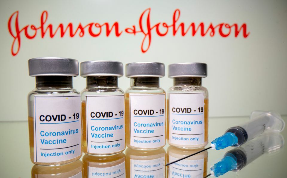 Vials with a sticker reading, Covid-19 / Coronavirus vaccine / Injection only and a medical syringe are seen in front of a displayed Johnson & Johnson logo in this illustration. — Reuters/File