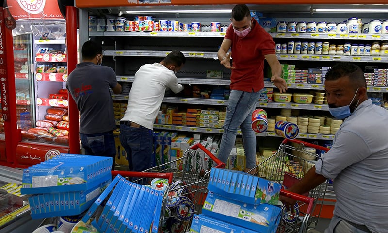 Workers at a supermarket in the Jordanian capital Amman remove French products off shelves during a boycott of French products on October 26. — AFP