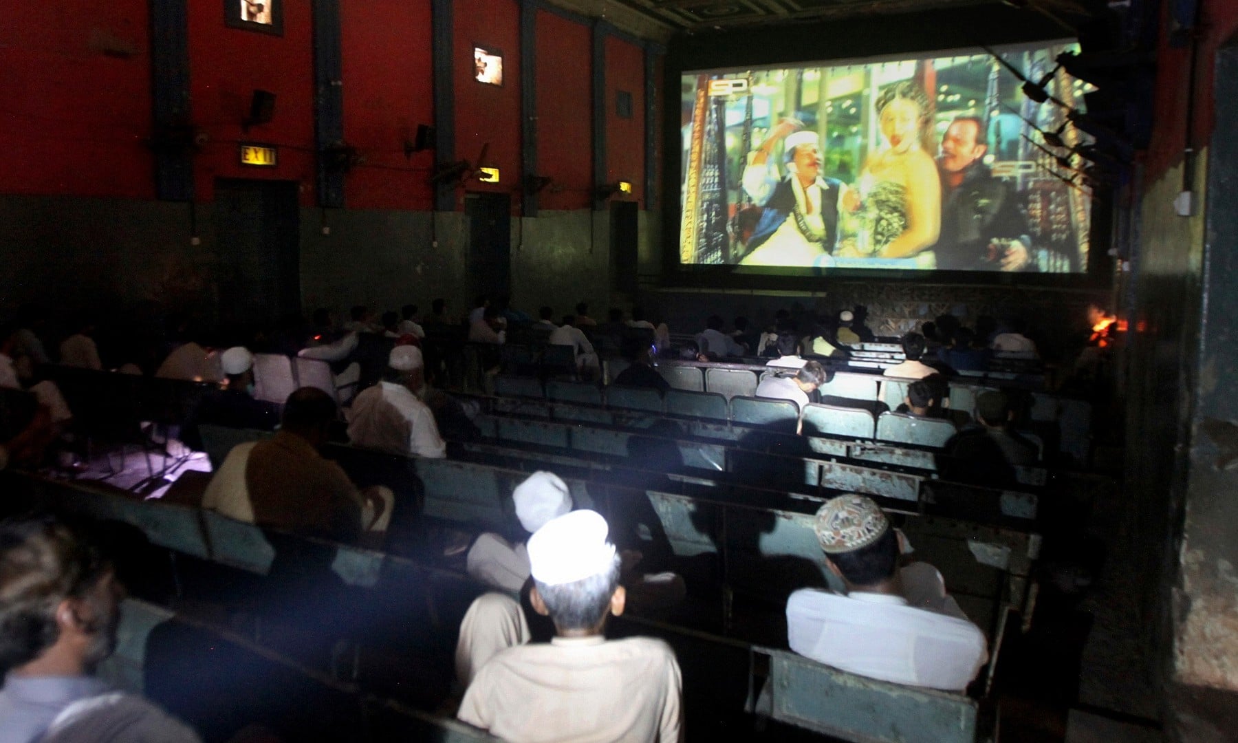 People watch a movie at a cinema following an ease in restrictions that had been imposed to help control the coronavirus in Peshawar on August 10. — AP
