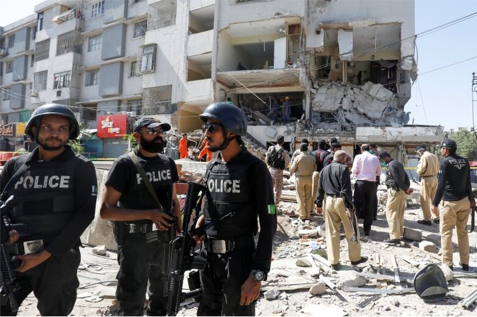 Police officers secure the site after an explosion in the multi-storey residential building in Karachi, Pakistan October 21, 2020.