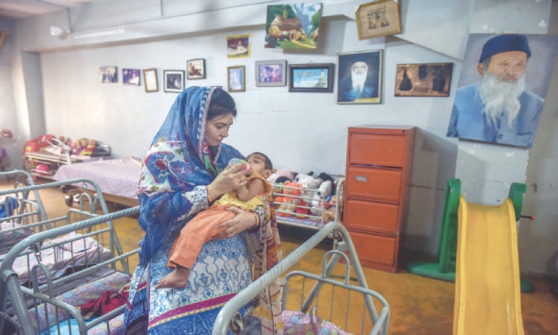 Sabah Faisal Edhi feeds a special child in the nursery of the Edhi Centre in Kharadar | Fahim Siddiqi / White Star