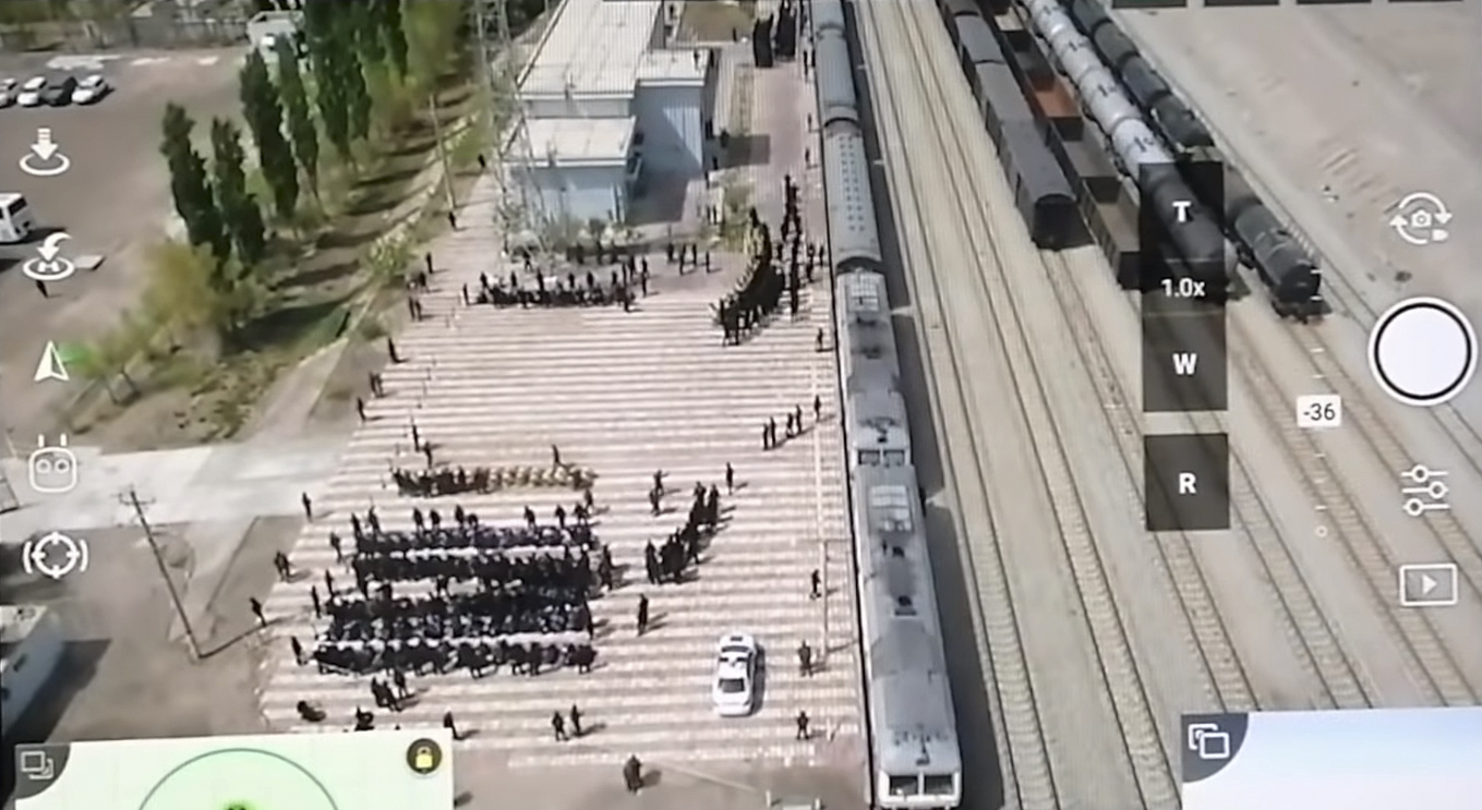 A still from drone footage which claims to show Uighur prisoners being piled onto trains in China