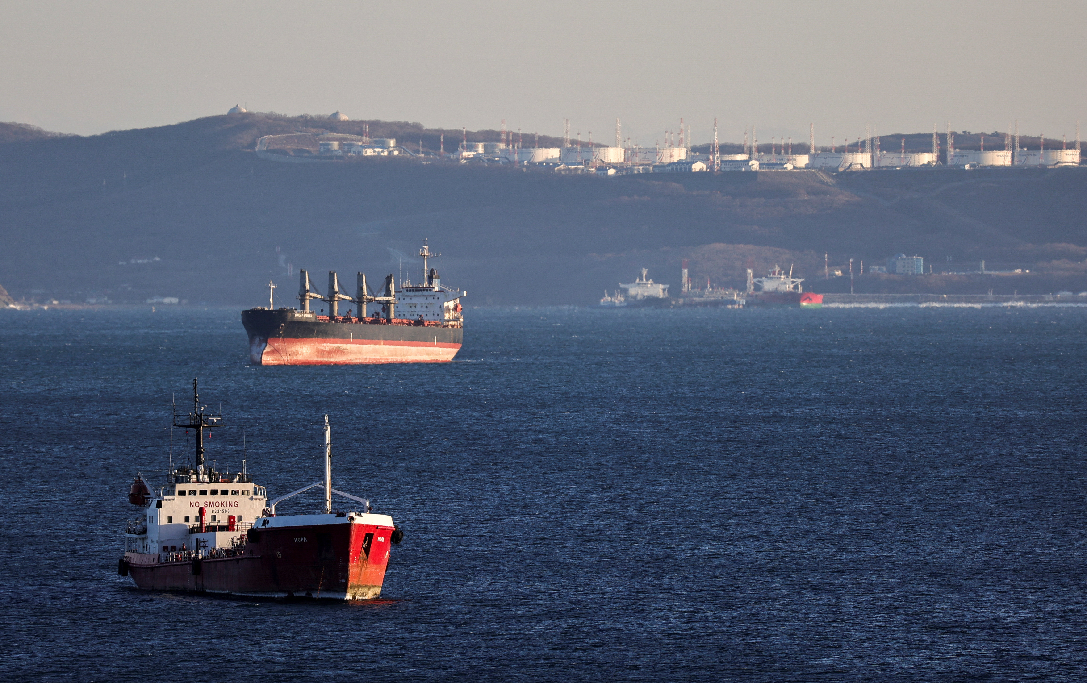 An oil tanker and bulk carrier sail near the crude oil terminal Kozmino in Nakhodka Bay