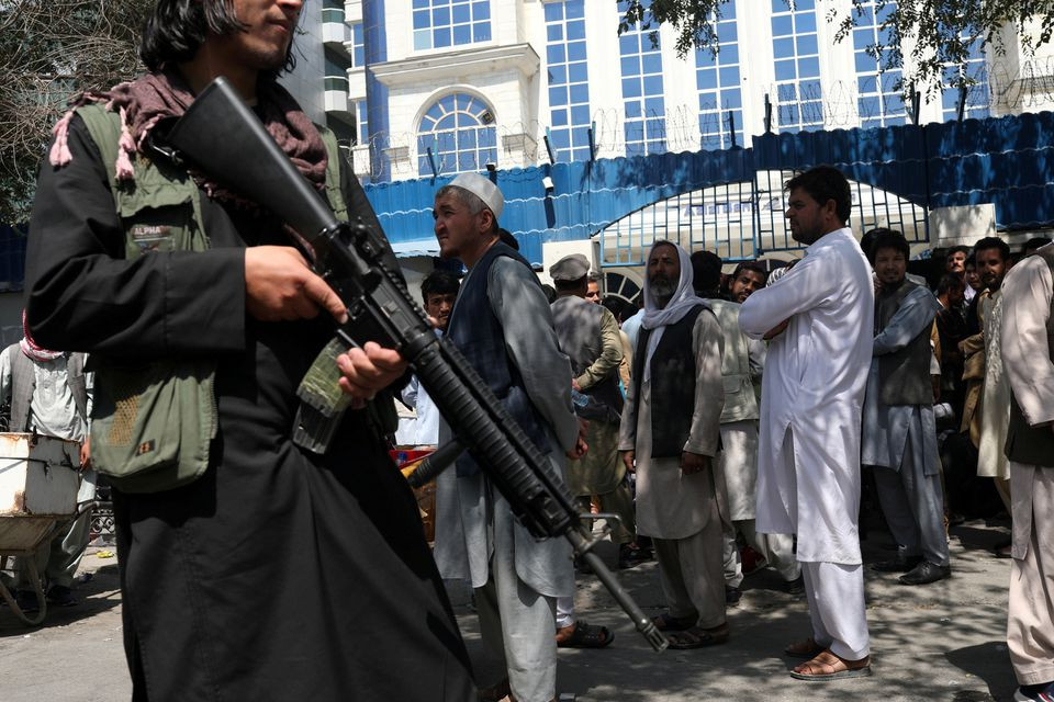 a taliban security member holding a rifle ensures order in front of azizi bank in kabul afghanistan september 4 2021 photo reuters file