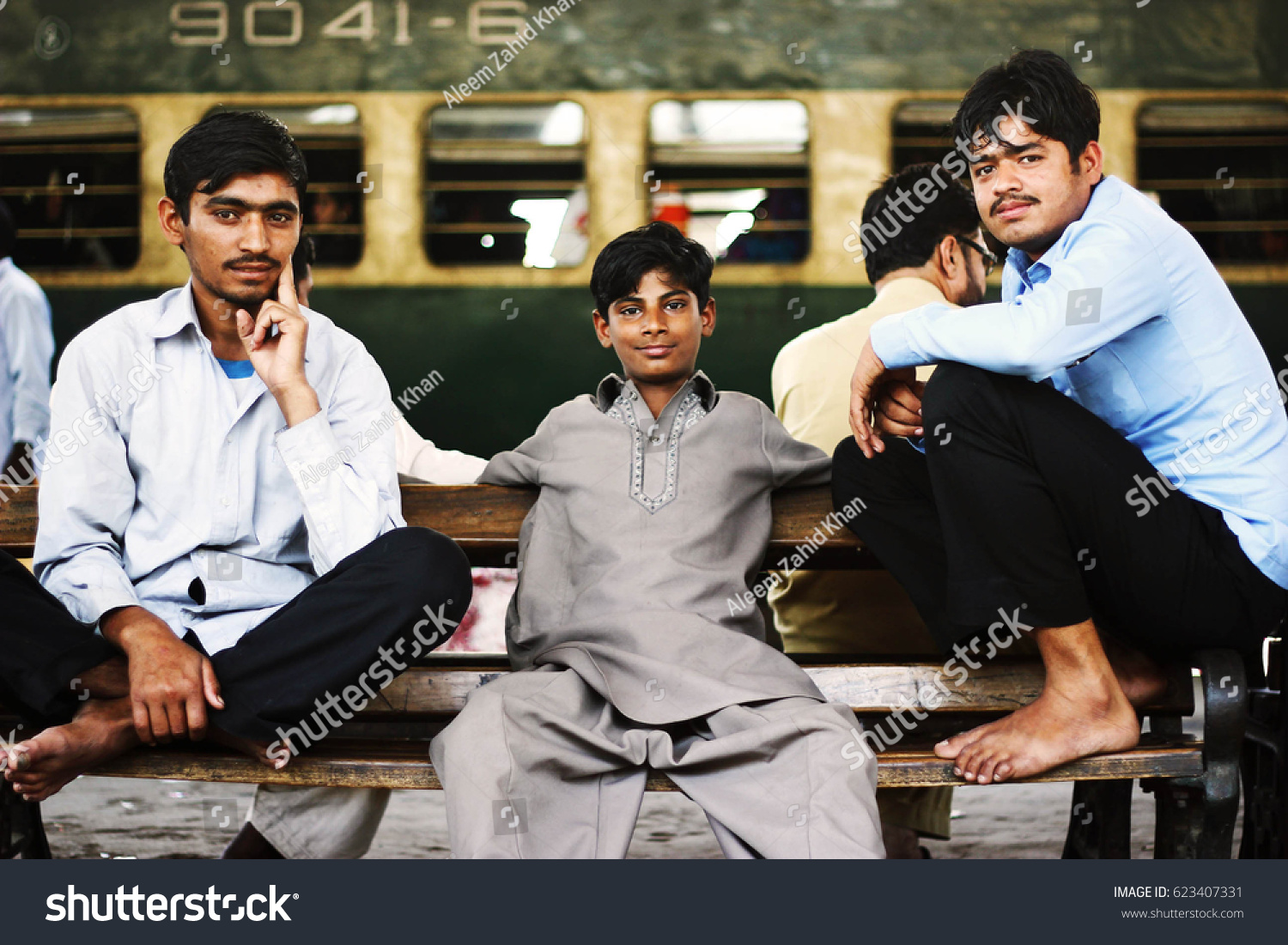 stock-photo-passengers-sitting-on-a-bench-and-waiting-for-their-train-at-karachi-cantt-station-623407331.jpg