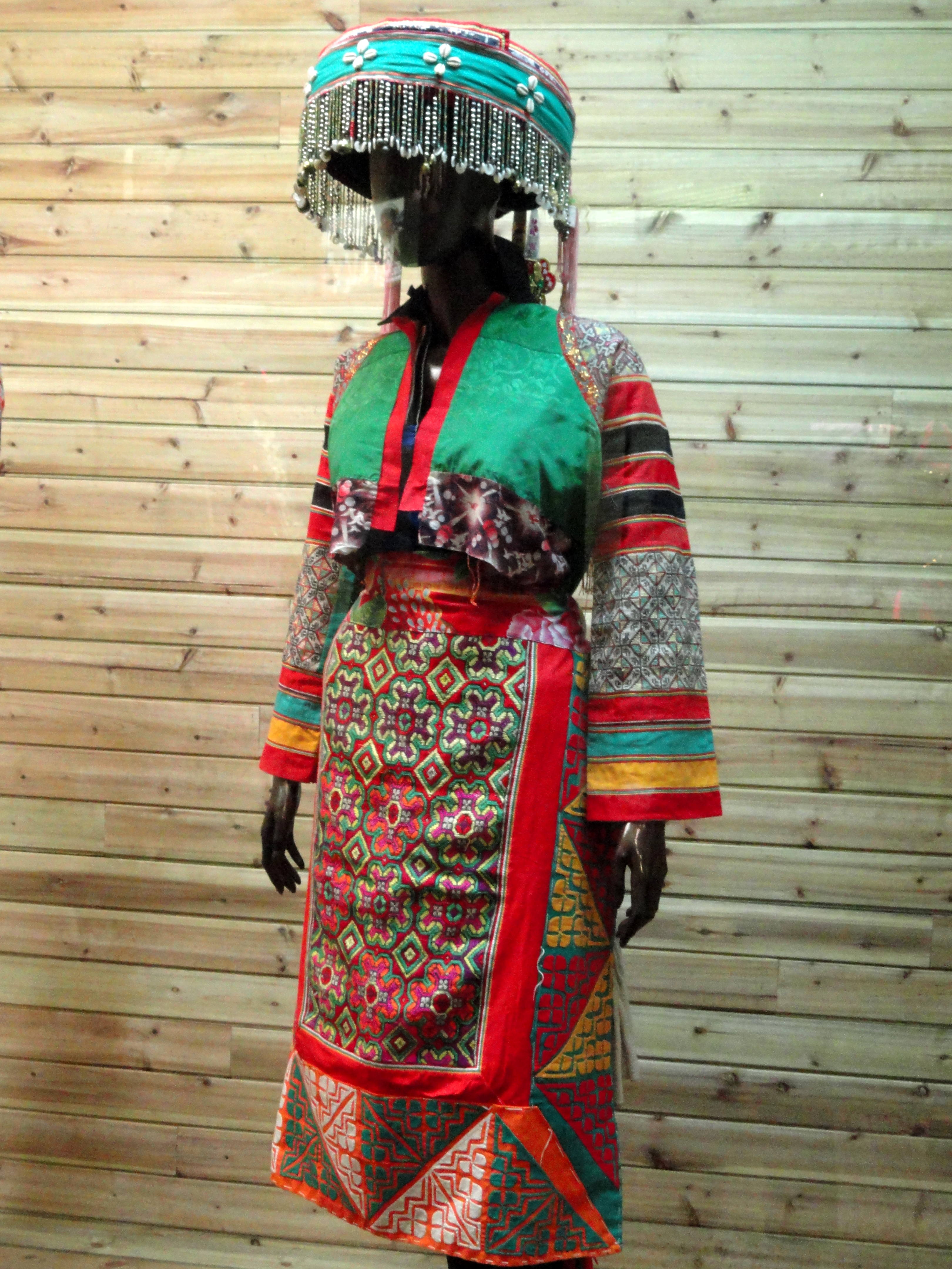 Miao_woman_cut-and-stick%2C_embroidered_dress_-_Yunnan_Nationalities_Museum_-_DSC04273.JPG