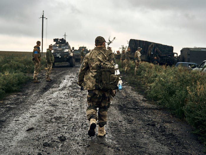 Ukrainian soldiers stand on the road in the freed territory of the Kharkiv region, Ukraine, Monday, Sept. 12, 2022.