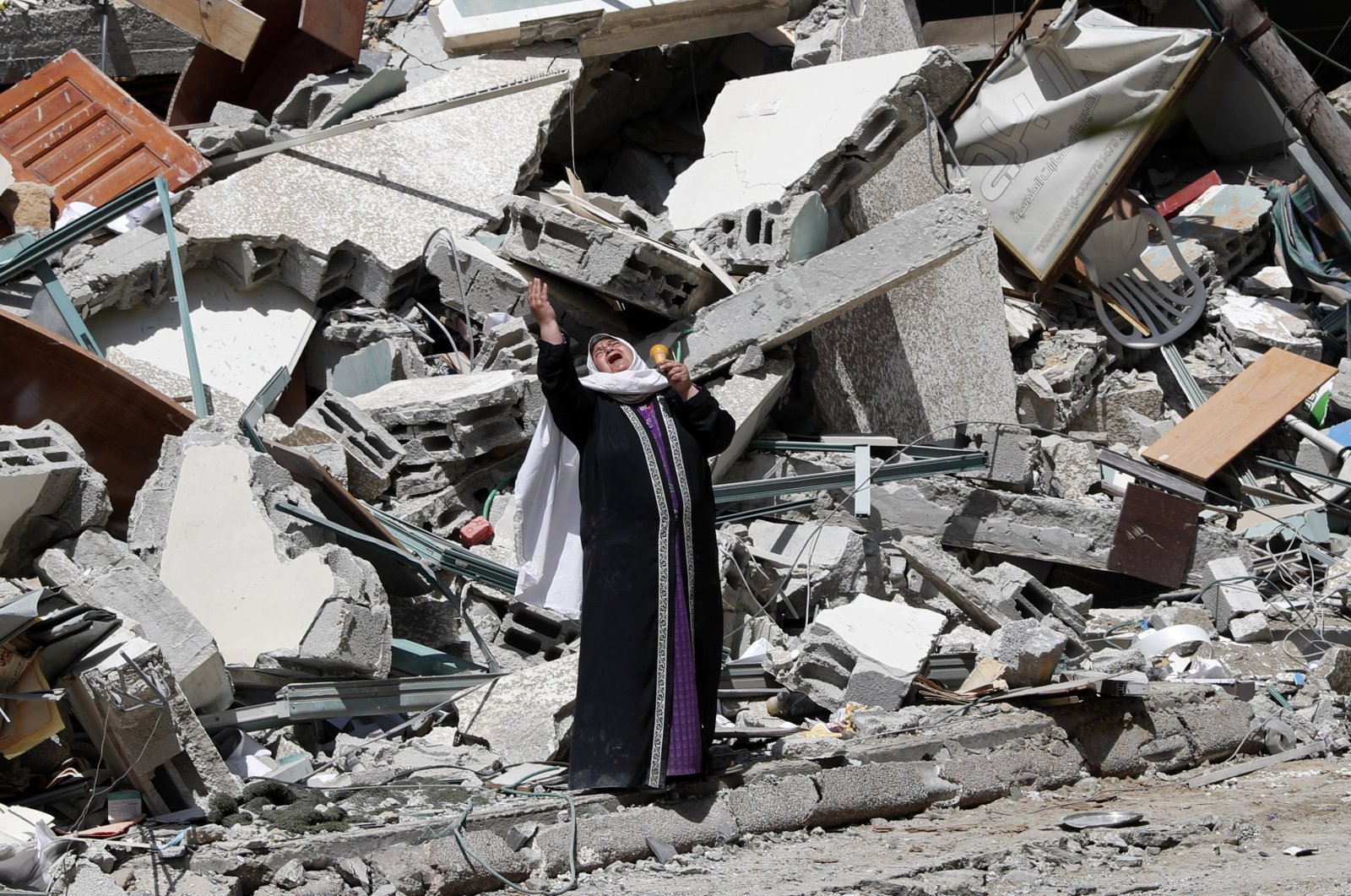 A woman reacts while standing near the rubble of a building that was destroyed by an Israeli airstrike in the Gaza Strip, Palestine, May 16, 2021. (AP Photo)