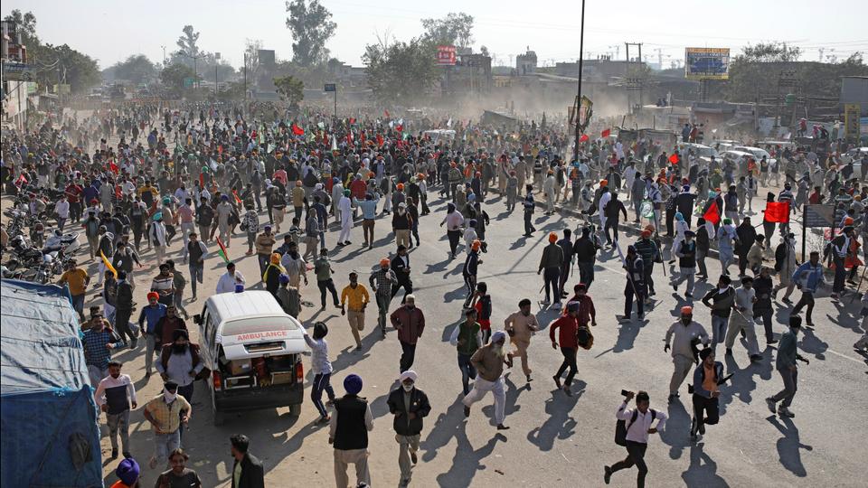 Protesting farmers run for cover as police use water cannon to disperse them as they attempt to move towards Delhi at the border between Delhi and Haryana state, November 27, 2020.