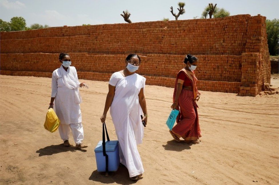 Healthcare workers arrive with doses of COVISHIELD, a coronavirus disease (COVID-19) vaccine manufactured by Serum Institute of India, to be administered to workers of a brick kiln at Kavitha village on the outskirts of Ahmedabad, India, April 8, 2021.