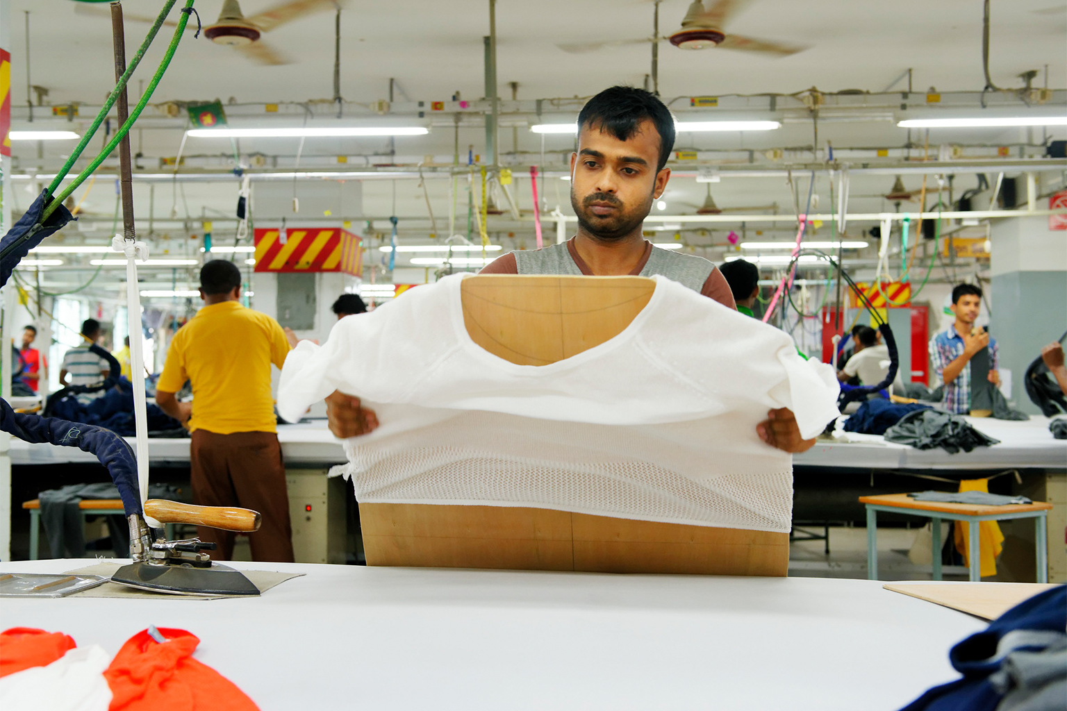 A garment worker is seen during his shift in a clothing plant. 