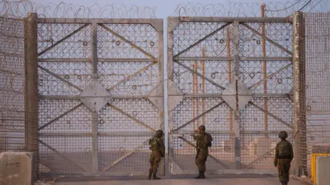 AFP Israeli soldiers check a gate as they patrol along the Israel-Gaza border area on October 21, 2024, amid the ongoing war between Israel and the Hamas militant group.