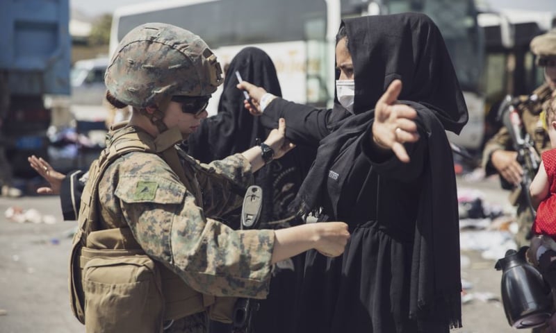 A US Marine checks a woman as she goes through the Evacuation Control Centre during an evacuation at Hamid Karzai International Airport, Kabul, Afghanistan on August 28. — Reuters
