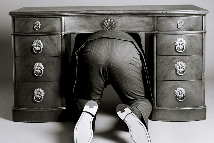 man-in-suit-hiding-beneath-desk.jpg