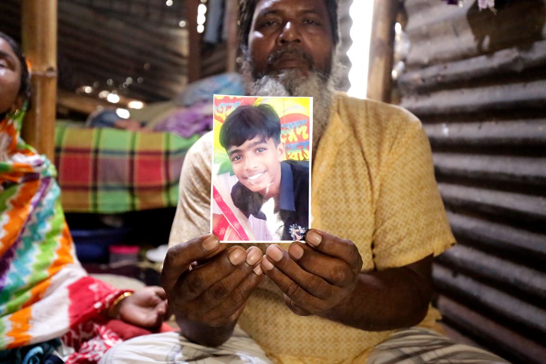 Mohammad Ramzan Ali holds a photo of his 13-year-old son Mubarak, who was killed during anti-government protests in Bangladesh.