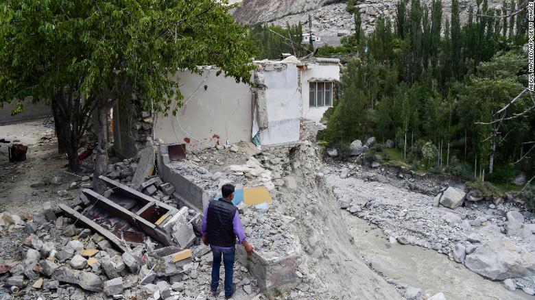 A local resident stands beside his damaged house in June after a glacial lake outburst unleashed catastrophic flooding in the northern Pakistan village of Hassanabad. 