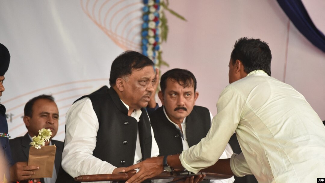 Bangladeshi pirates lay down their weapons to Bangladesh Home Minister Asaduzzaman Khan, center, as they surrender, in Cox's Bazar on Nov. 23, 2019.