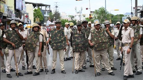 Police stand guard as Hindu groups activists and demonstrators (not pictured) hold a protest rally against the killing of Hindu tailor Kanhaiya Lal, who was allegedly killed by two Muslim men for supporting a former spokeswoman of the ruling BJP for her remarks about the Prophet Mohammed, in Udaipur in Thursday. (AFP)