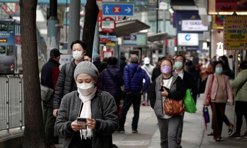 Pedestrians wearing face masks following Covid-19 outbreak walk on a street at Causeway Bay district in Hong Kong on February 9. — Reuters