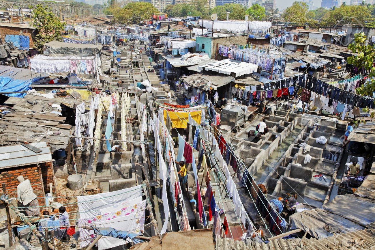 12848568-Mumbai-Dhobhi-ghat-assembly-line-of-wash-tubs-and-bays-with-washed-laundry-out-to-dry-on-washing-lin-Stock-Photo.jpg