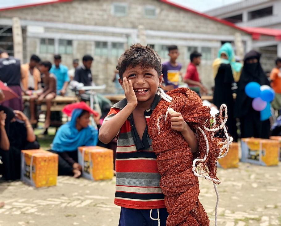 The government distributed livelihood materials among Rohingyas in Bhasan Char on 16 July 2021. A seven-year-old boy is elated with the fishing net given to his father. 