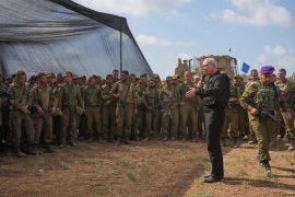 Israel's Defence Minister Yoav Gallant, wearing a protective vest, speaks with Israeli soldiers in a staging area near the border with the Gaza Strip in southern Israel, Thursday, October 19 [Tsafrir Abayov/AP Photo]