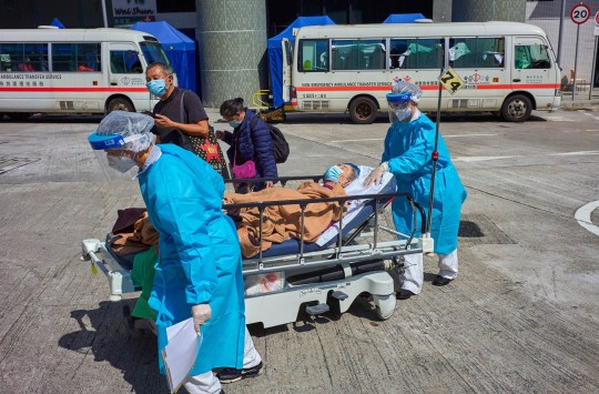 Mandatory Credit: Photo by Emmanuel Serna/SOPA Images/REX/Shutterstock (12828691e) Medical staff transport a covid-19 patient on a stretcher at the Caritas Medical Center in Hong Kong. Hong Kong hospitals are overwhelmed as the city is facing its worst-ever coronavirus outbreak. Hospitals overwhelmed as covid-19 cases rise in Hong Kong, China - 01 Mar 2022