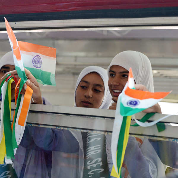 Kashmiri-schoolgirls-wave-Indian-national-flags-during-a-flagging-off-ceremony-attended-by-Indian-Prime-minister-Manmohan-Singh-and-Congress-party-President-Sonia-Gandhi-for-a-train-service-running-between-Banihal-and-Qazigund-at-a-station-in-Banihal-some-110-kms-south-of-srinagar-on-June-26-2013-.jpg