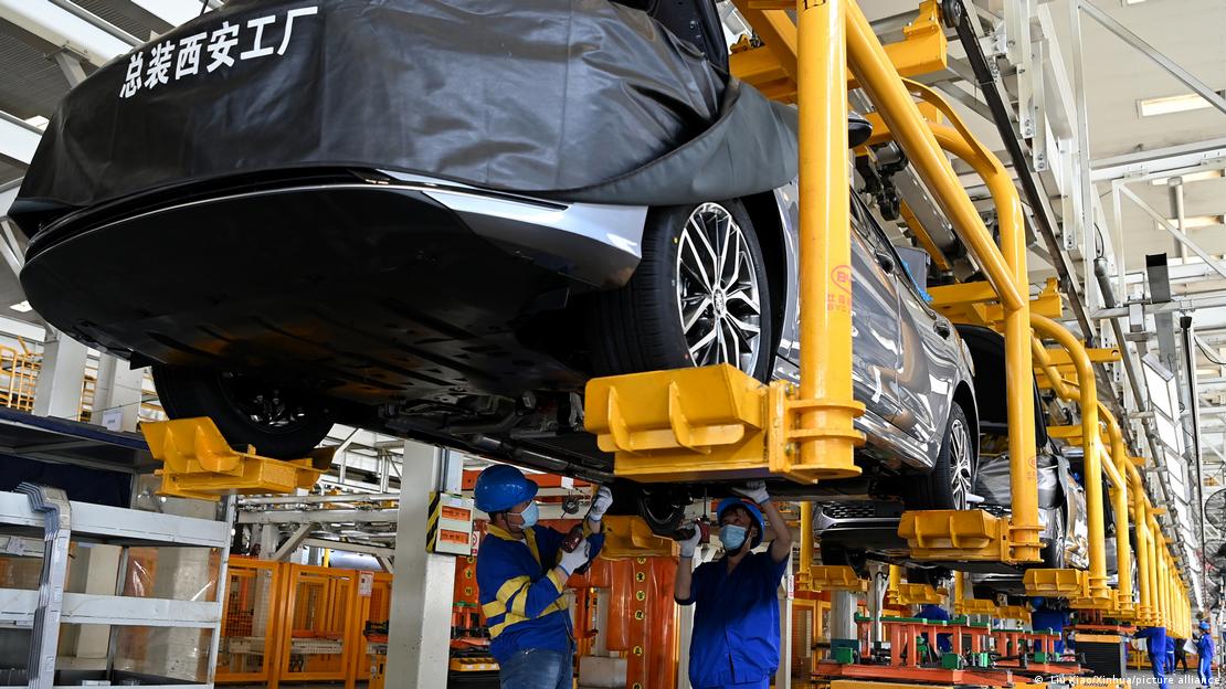 Staff members assemble new energy vehicles on the assembly line of BYD auto plant in Xi'an, northwest China's Shaanxi Province,