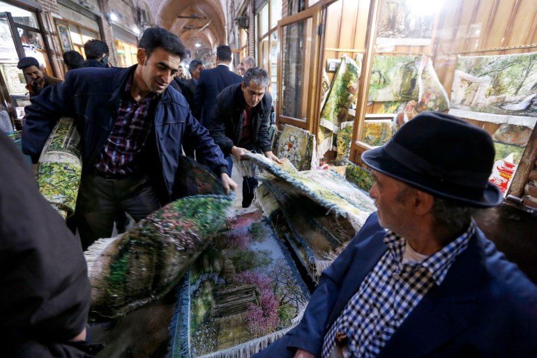 A picture taken on April 24, 2018 shows Iranians shopping for carpets at the Bazaar in Tabriz in Iran's northwestern East-Azerbaijan province [Atta Kenare/AFP]