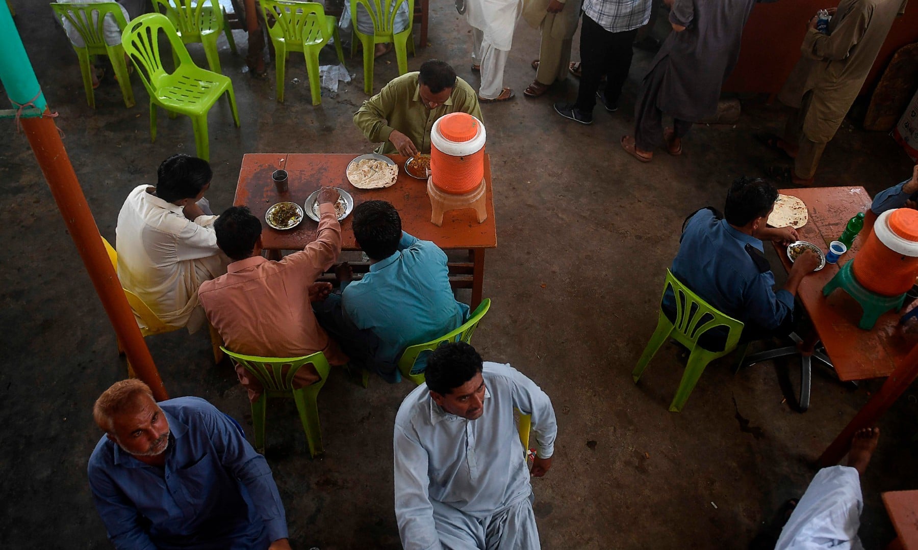 People eat at a restaurant in Karachi on August 10 after the government announced it would be lifting most of the country's remaining coronavirus restrictions. — AFP